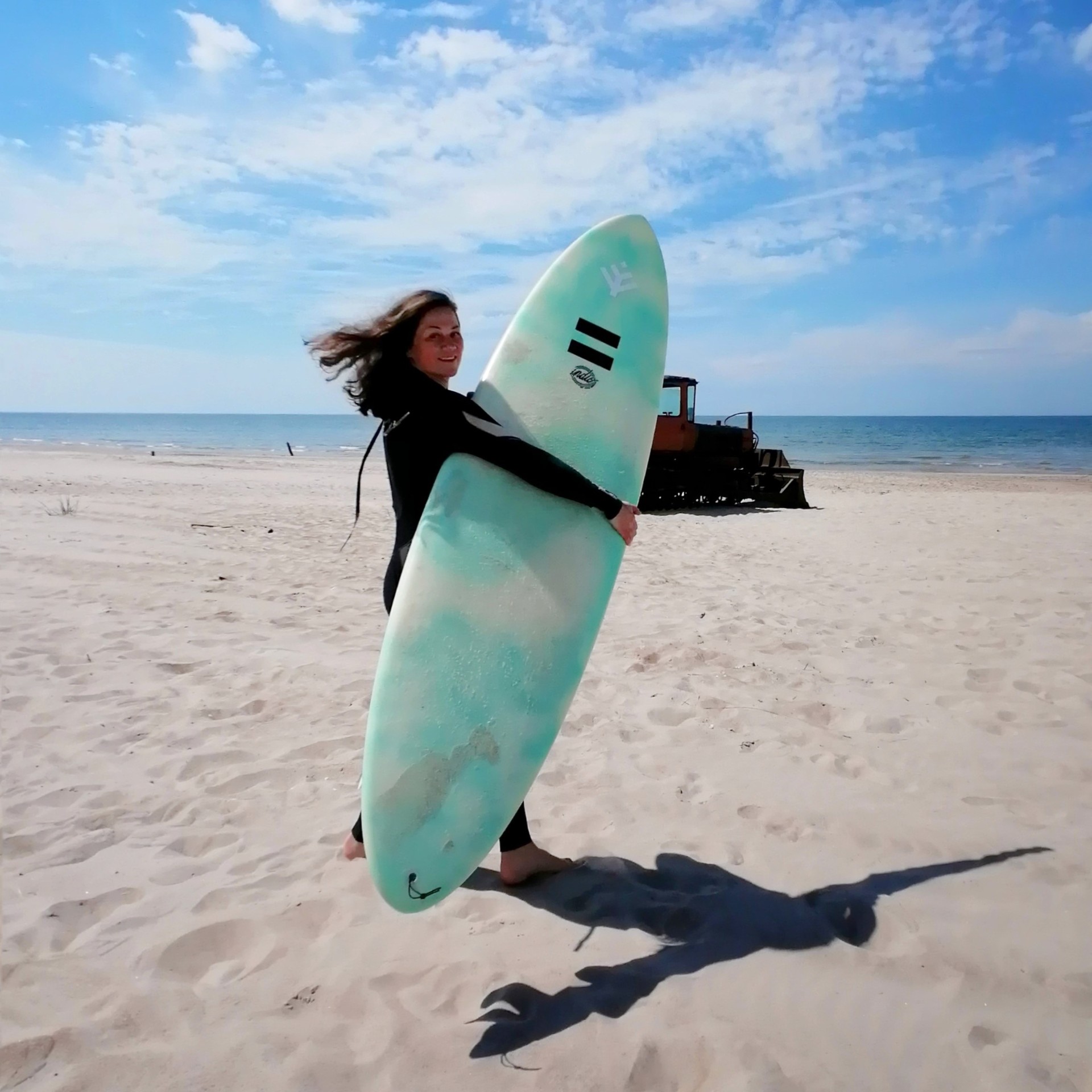 Ieva Drazniece with a surfboard on the beach